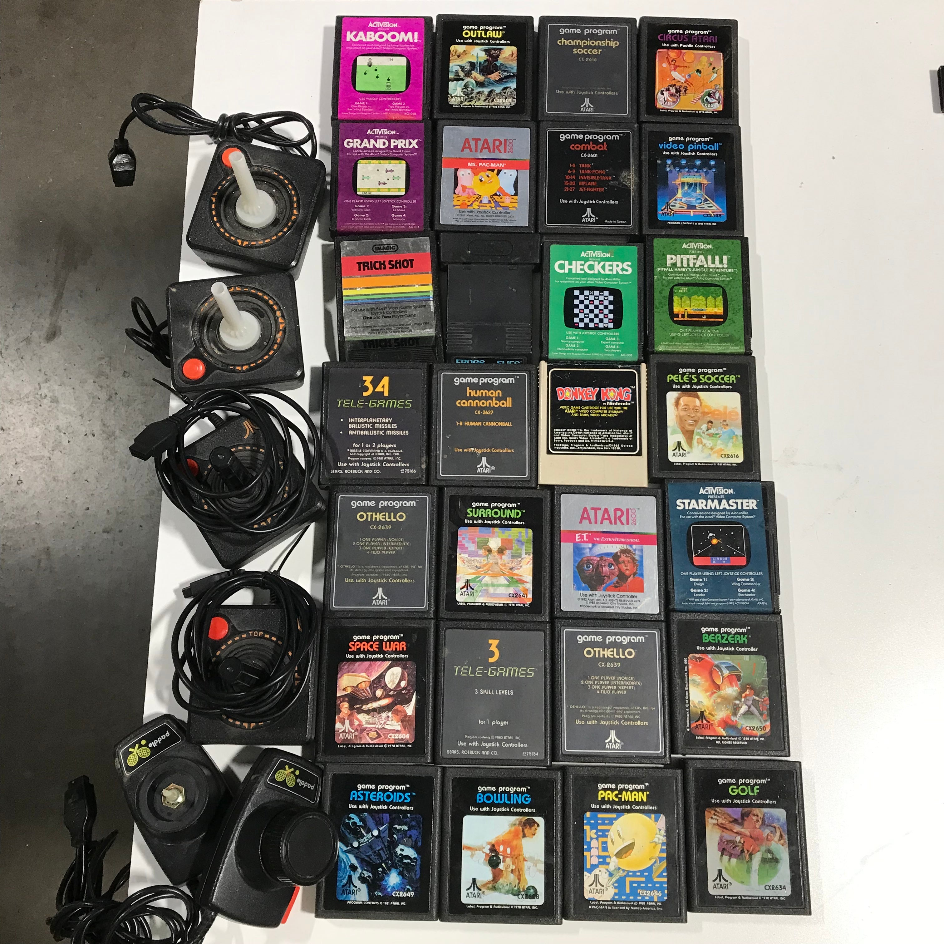28 Various Atari Game Cartridges and 4 Joysticks/2 Paddles